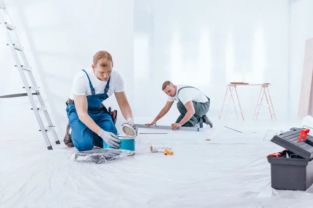 Interior house painting service showcasing a painter during interior finishing work in a commercial space.