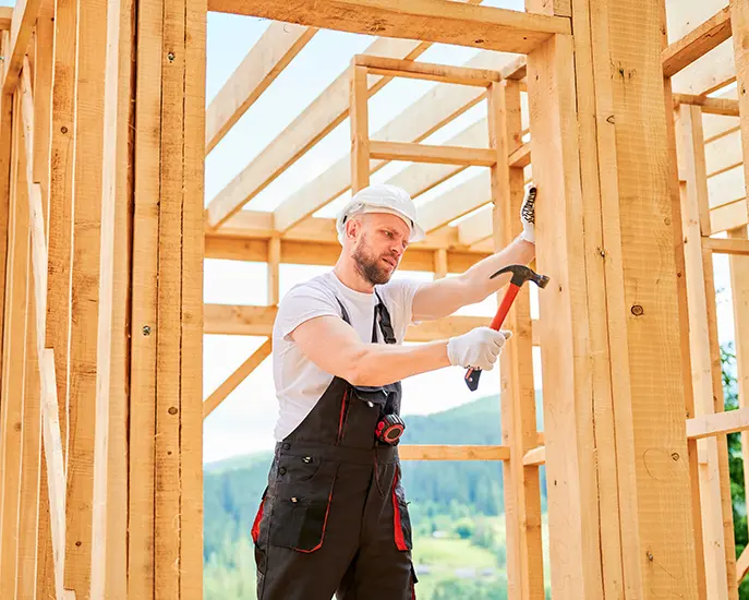 Construction worker framing a wooden structure during a home building project.
