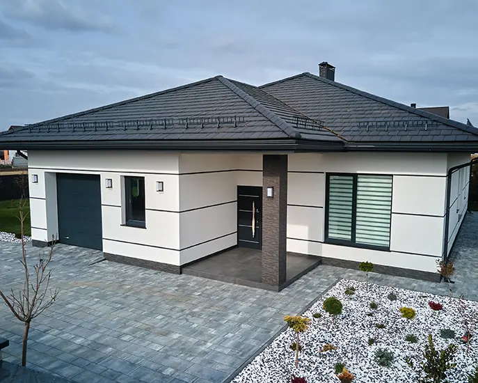 Modern house with a freshly painted white and gray exterior and a landscaped yard.