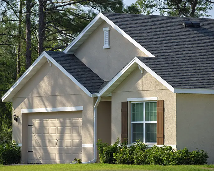 Beige house with a freshly painted exterior and a landscaped yard.