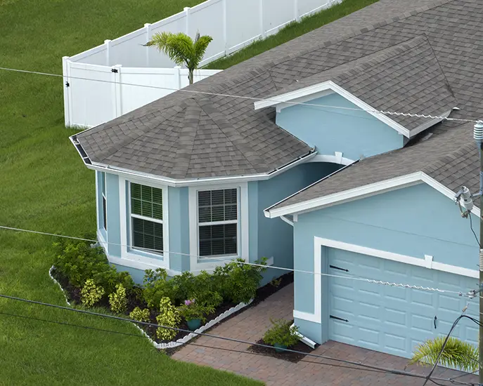 Newly painted light blue house exterior with a landscaped yard.