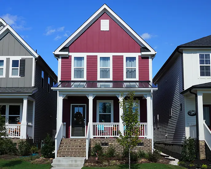 Freshly painted red and white house exterior with a front porch.