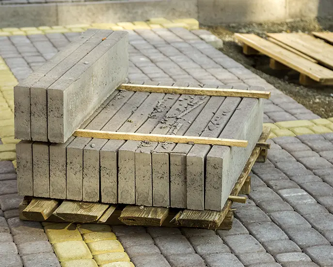 Concrete pavers stacked on a pallet during a stone installation project.