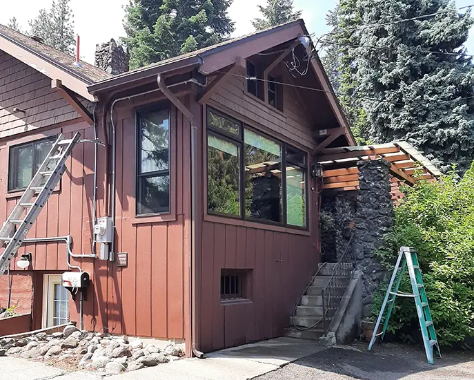 Rustic home with fresh brown exterior paint surrounded by trees.
