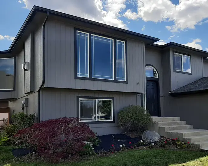Freshly painted grey exterior of a modern home with large windows.